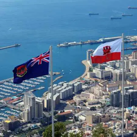 Powiewające flagi Gibraltaru i Wielkiej Brytanii nad portem jachtowym.