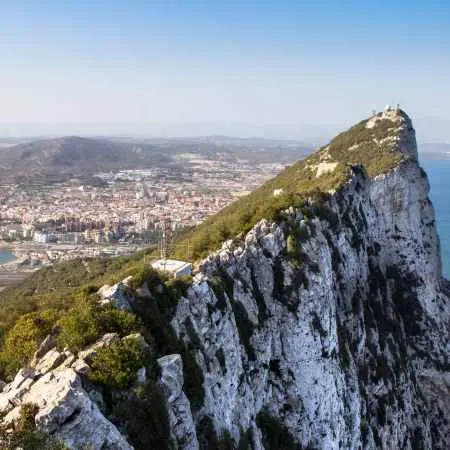 Charakterystyczna, ostra grań Skały Gibraltarskiej oraz widok na pas startowy lotniska i sąsiadujące, hiszpańskie miasto La Línea de la Concepción.